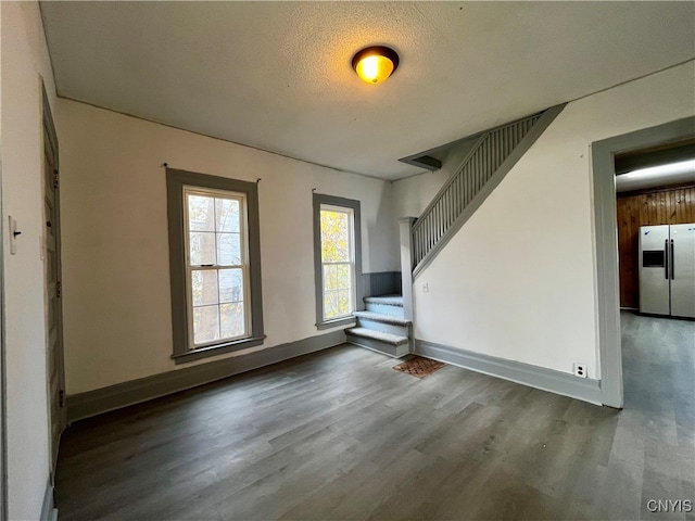 unfurnished living room featuring a textured ceiling and hardwood / wood-style flooring