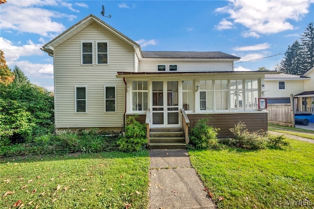 view of front facade with a sunroom and a front lawn