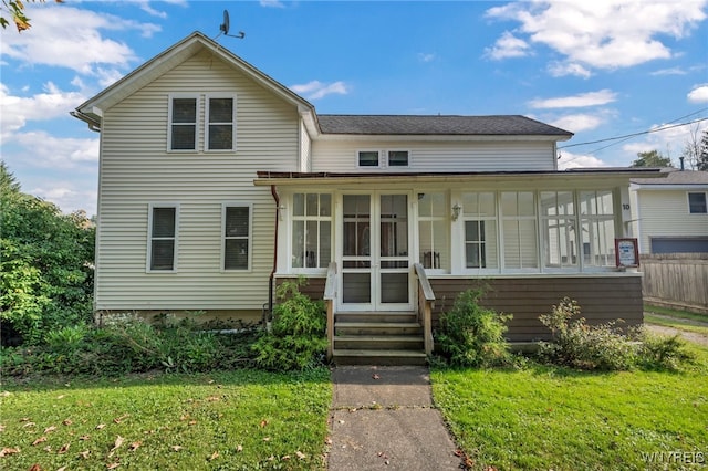 view of front facade featuring a sunroom and a front lawn