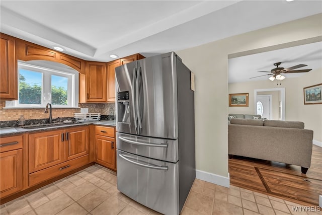 kitchen with stainless steel fridge with ice dispenser, sink, tasteful backsplash, light tile patterned floors, and ceiling fan