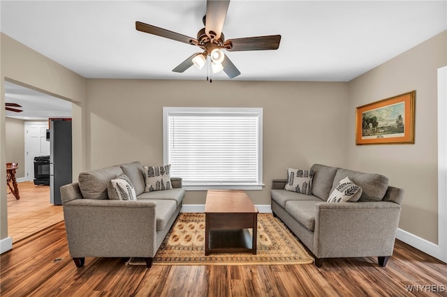 living room featuring ceiling fan and light wood-type flooring