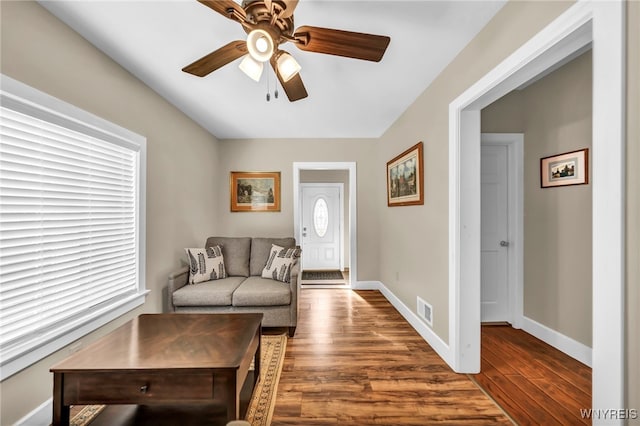 living room featuring wood-type flooring, ceiling fan, and a wealth of natural light