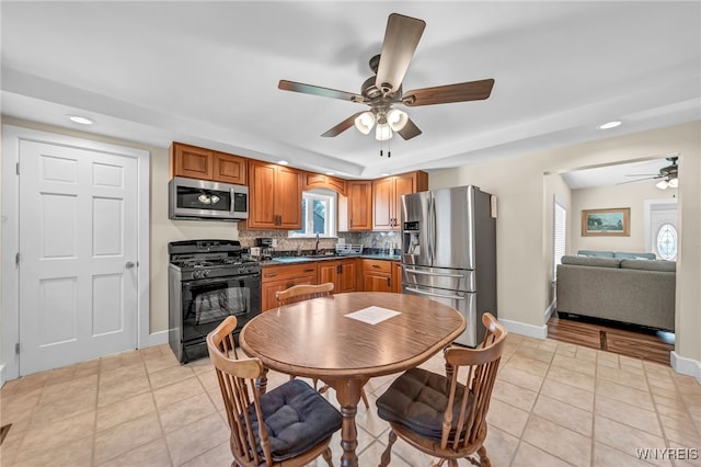 kitchen featuring ceiling fan, sink, light tile patterned floors, tasteful backsplash, and stainless steel appliances