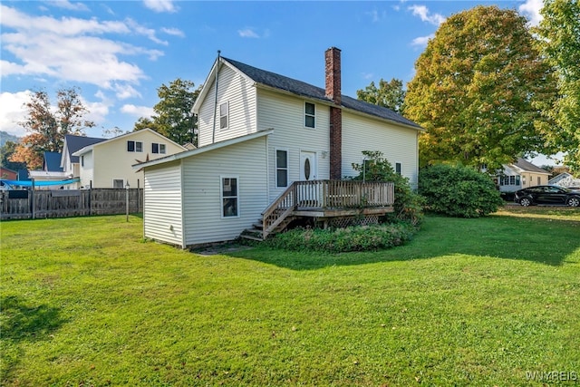 back of house with a lawn and a wooden deck