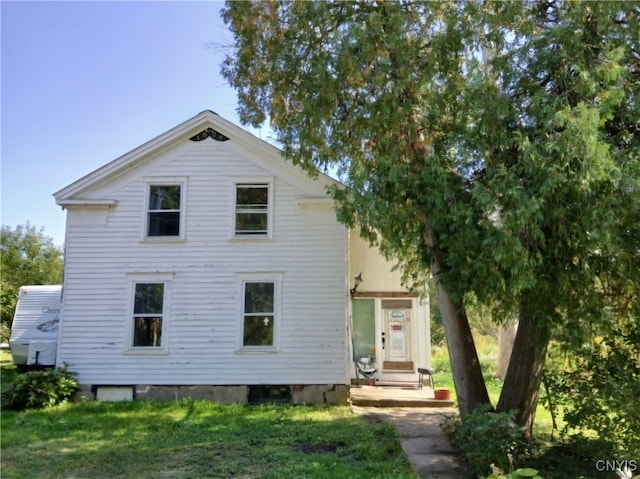 rear view of property featuring a yard