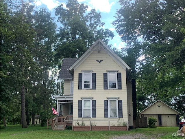 view of front of home with an outdoor structure, a front lawn, and covered porch