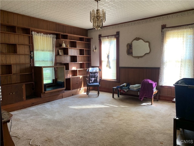 sitting room with an inviting chandelier, plenty of natural light, and carpet floors