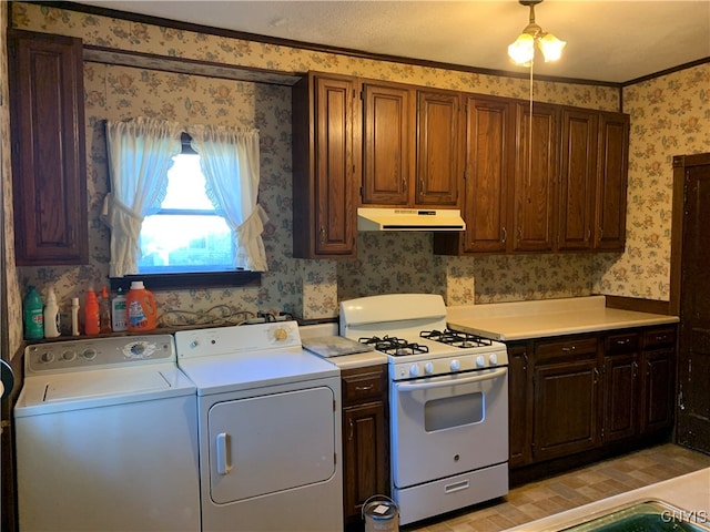 kitchen featuring light hardwood / wood-style floors, gas range gas stove, ceiling fan, washer and clothes dryer, and ornamental molding