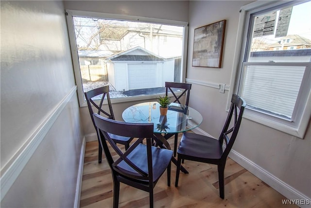 dining space with wood-type flooring