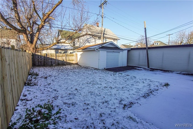 snowy yard with an outbuilding and a garage