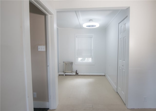 corridor featuring ornamental molding and radiator