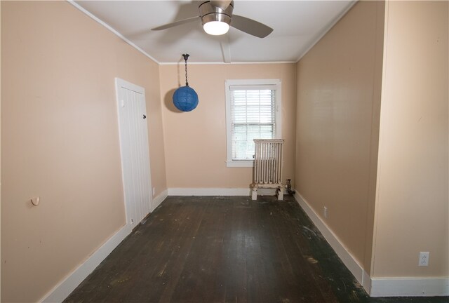 spare room with crown molding, ceiling fan, and dark wood-type flooring