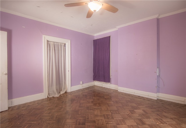 spare room with ceiling fan, dark parquet flooring, and ornamental molding