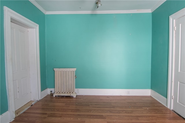 spare room with wood-type flooring, radiator, and crown molding