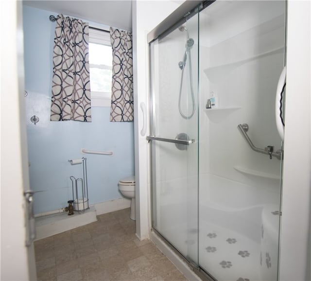 bathroom with toilet and a shower with shower door