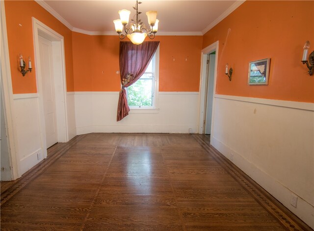 empty room with ornamental molding and an inviting chandelier