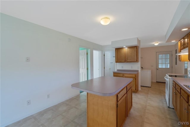 kitchen with a center island, washer / dryer, and electric stove