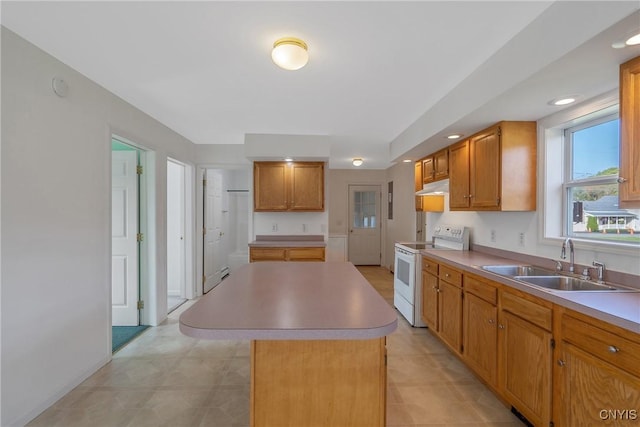 kitchen featuring white range with electric cooktop, a kitchen island, and sink