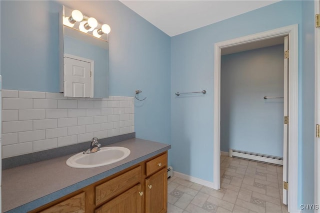 bathroom featuring vanity, backsplash, and baseboard heating