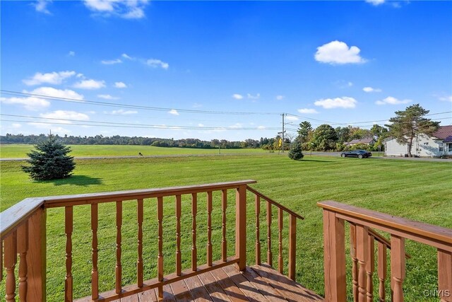 wooden deck featuring a yard and a rural view