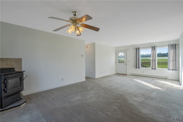 unfurnished living room featuring carpet floors, a baseboard radiator, a wood stove, and ceiling fan