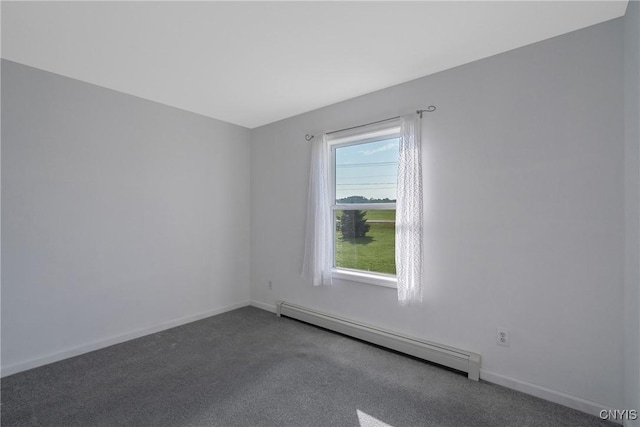 spare room with baseboard heating and carpet