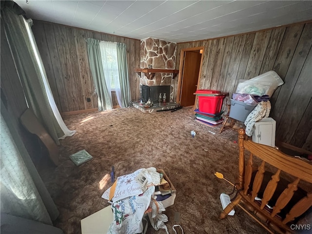 misc room with wooden walls, carpet flooring, and a stone fireplace