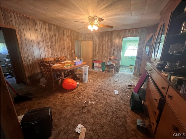 interior space featuring wooden walls, ceiling fan, and carpet floors