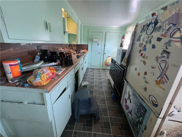 kitchen featuring white cabinets, sink, and white fridge