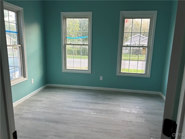 unfurnished room with light wood-type flooring and plenty of natural light