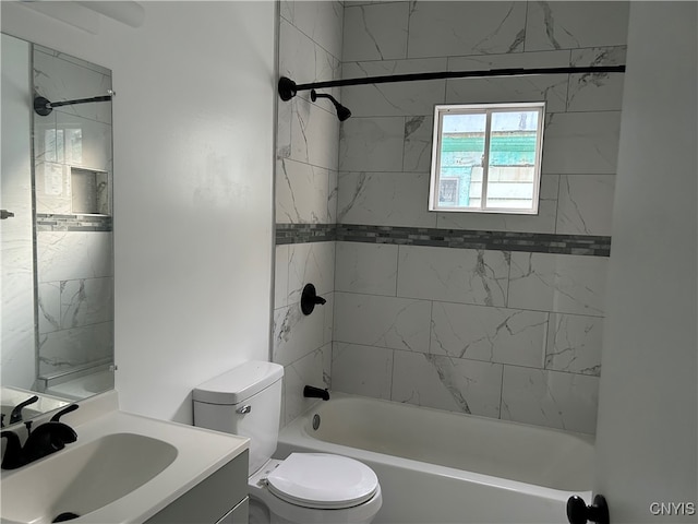 full bathroom featuring tiled shower / bath, vanity, and toilet