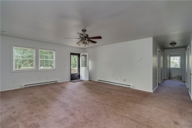 carpeted empty room with ceiling fan, a baseboard radiator, and a healthy amount of sunlight