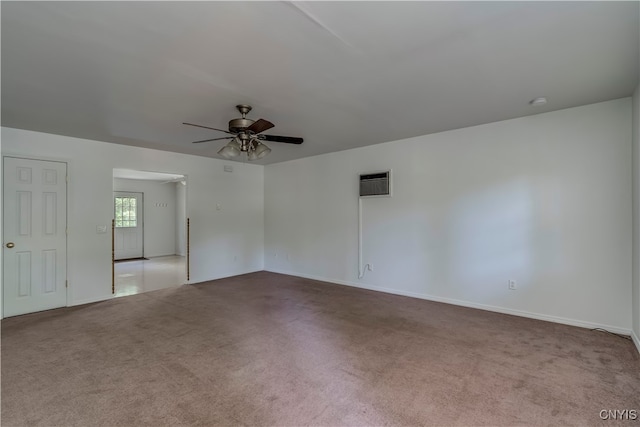 empty room with ceiling fan, light carpet, and a wall mounted air conditioner