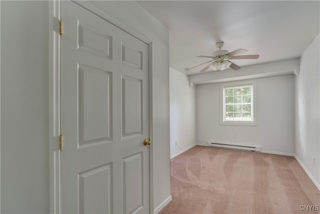 empty room with ceiling fan, light carpet, and a baseboard heating unit