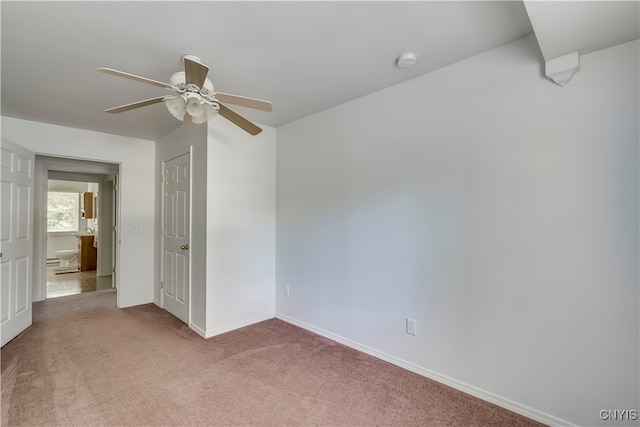 carpeted spare room featuring ceiling fan