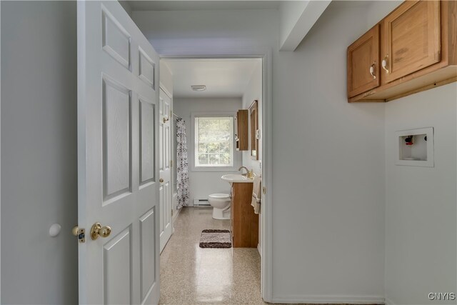 corridor featuring sink and a baseboard heating unit