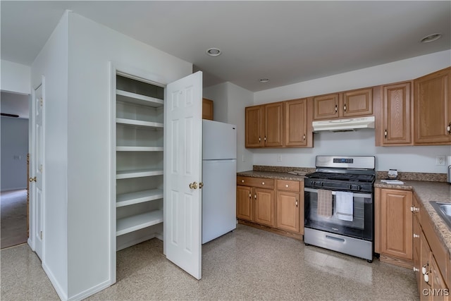 kitchen featuring white refrigerator and stainless steel range with gas cooktop