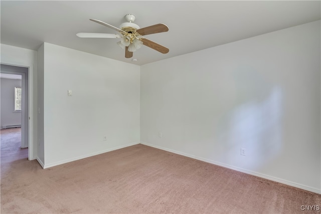 carpeted spare room with ceiling fan and a baseboard radiator