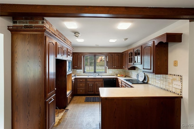 kitchen featuring dark brown cabinetry, sink, kitchen peninsula, black appliances, and decorative backsplash