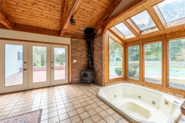 interior space featuring vaulted ceiling with skylight, a wood stove, and a wealth of natural light