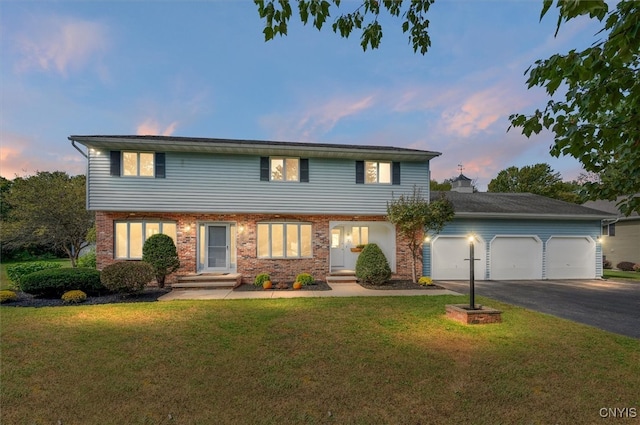 view of front of home with a garage and a yard