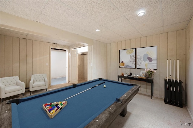 game room with pool table, a drop ceiling, wood walls, and carpet floors