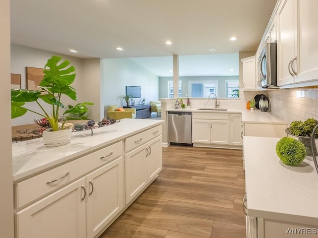 203 Carriage Ln, West Seneca, NY 14224 - kitchen with appliances with stainless steel finishes, a sink, backsplash, white cabinets, and recessed lighting