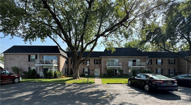 view of front of house featuring a balcony and a front yard