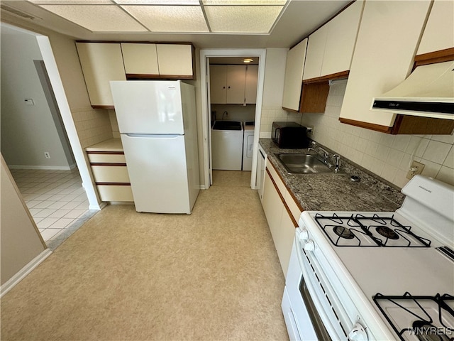 kitchen with sink, white appliances, tasteful backsplash, independent washer and dryer, and range hood