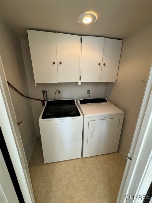 washroom with washer and dryer, light colored carpet, and cabinets