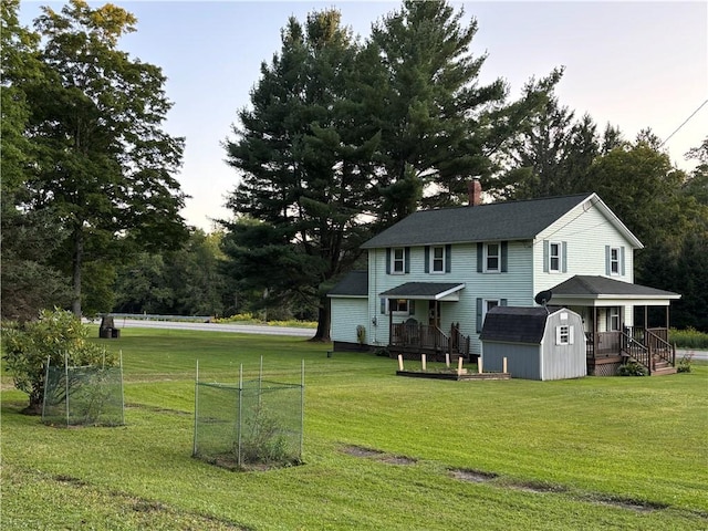 exterior space with a lawn, an outbuilding, a chimney, and a shed