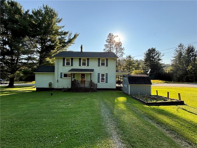 view of front of property featuring a vegetable garden, a storage shed, an outdoor structure, and a front yard