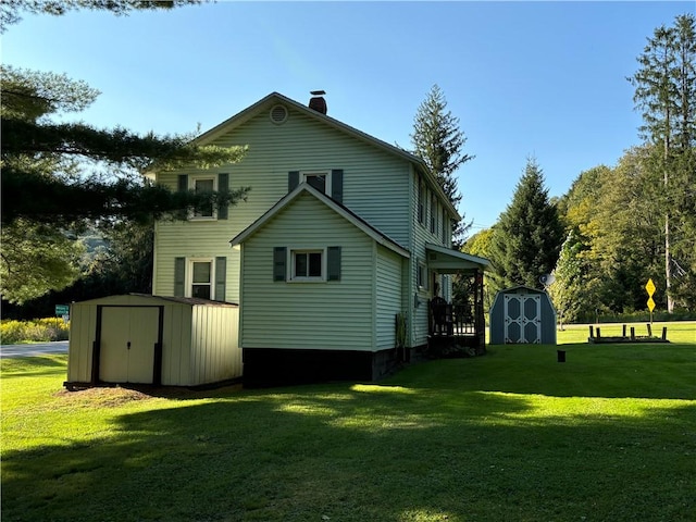 rear view of house with an outdoor structure, a storage unit, a yard, and a chimney