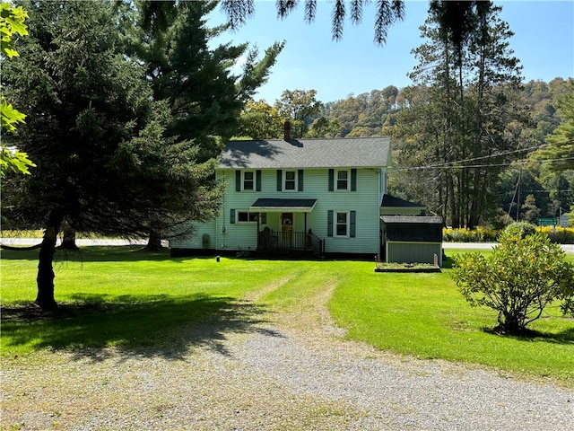 colonial home featuring a shed and a front yard